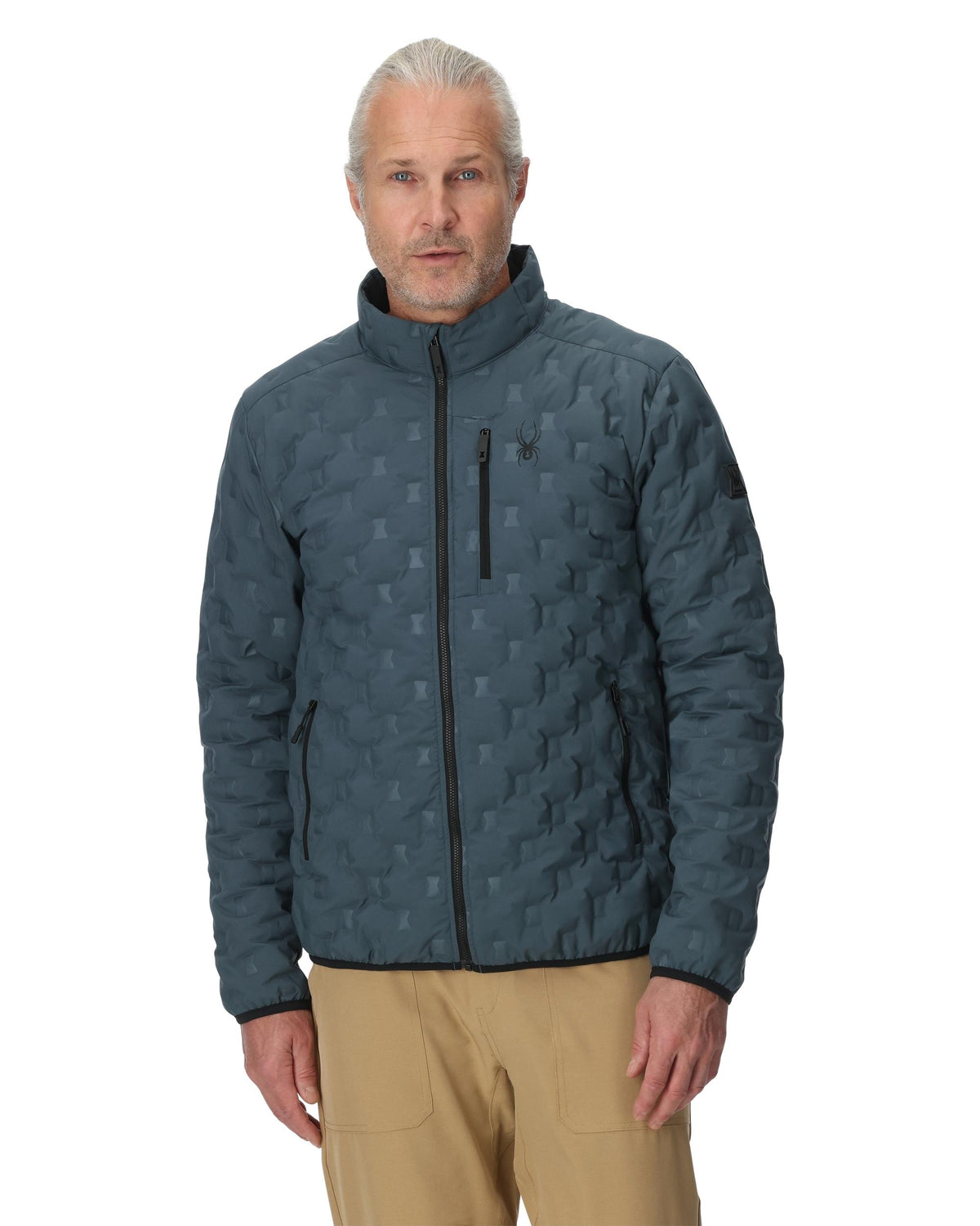 Man wearing a blue quilted jacket on a white background