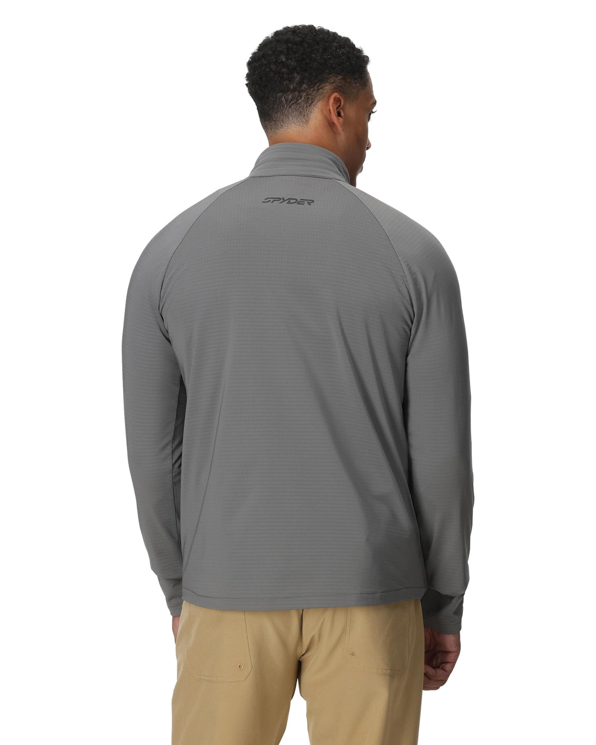 Man wearing a gray long-sleeve shirt with a brand logo on the back, standing against a white background.
