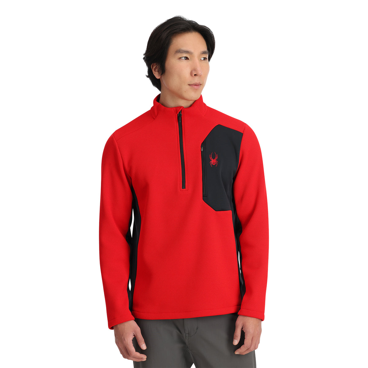 A man wearing a red Spyder half zip jacket with a black chest pocket and the Spyder logo on the chest.