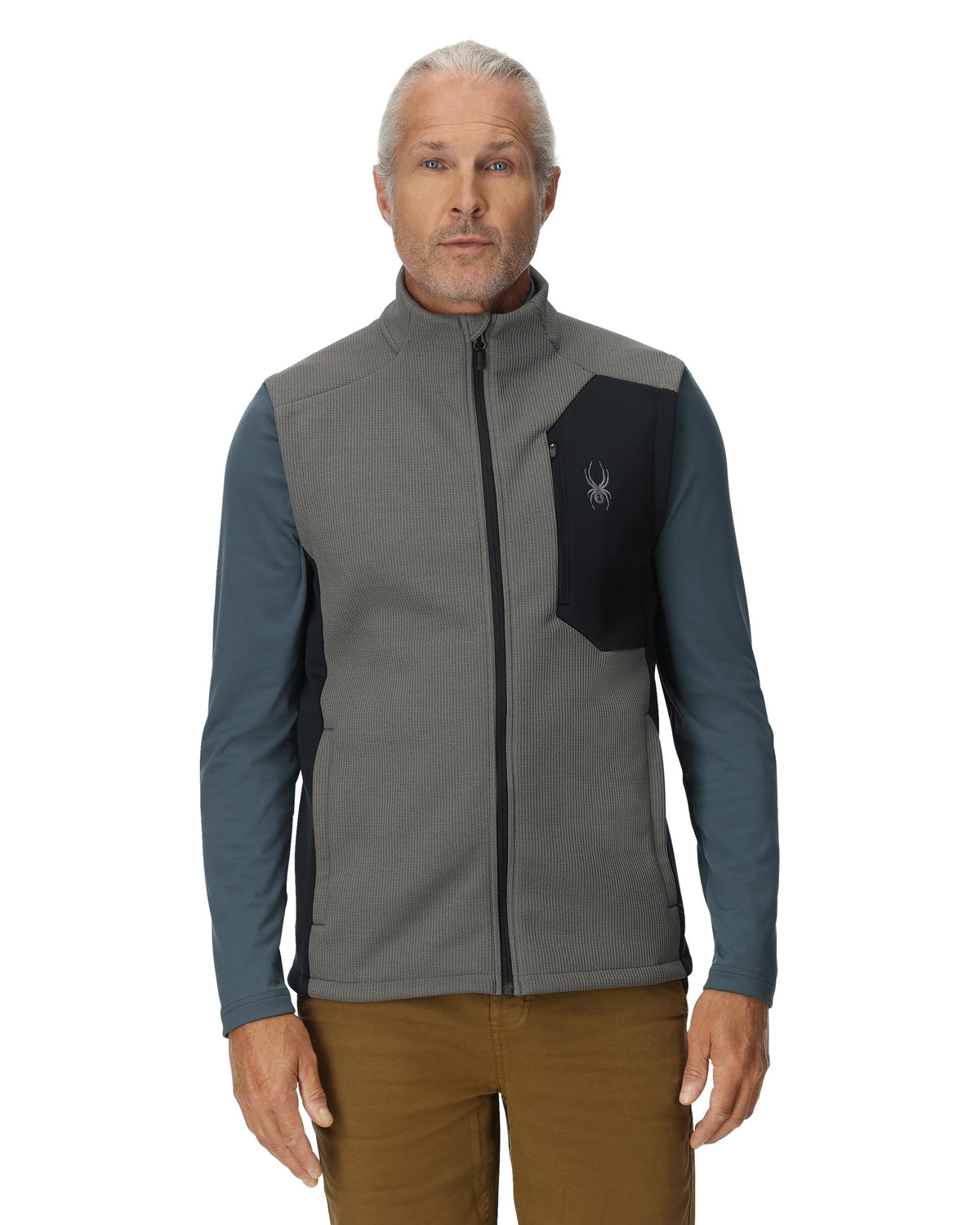 Man wearing a gray and blue jacket with a logo on a white background