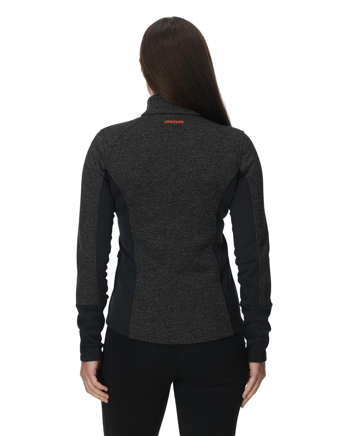 Person wearing a dark gray jacket with a brand logo on the back against a white background