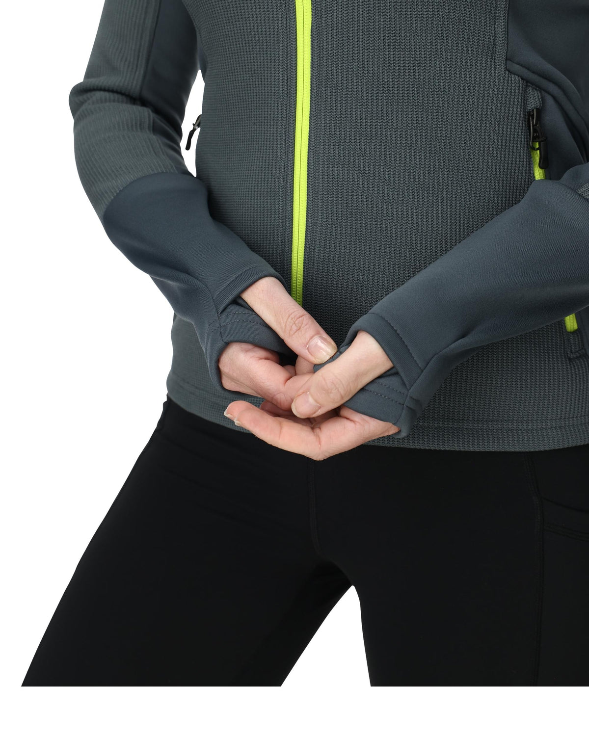 Person wearing a gray jacket with a green zipper, holding hands together.