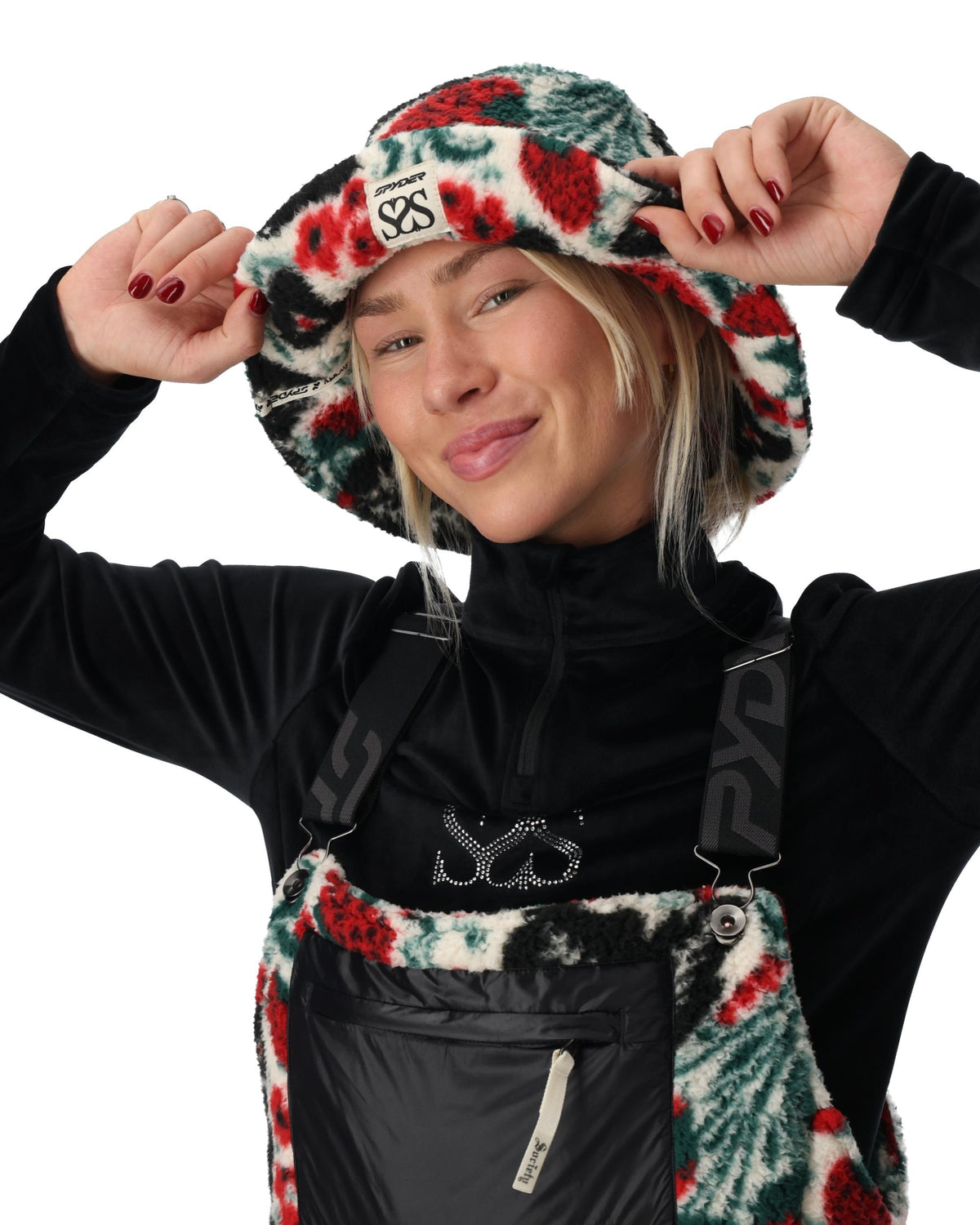 Person wearing a black jacket with floral patterns and a brand logo on a white background
