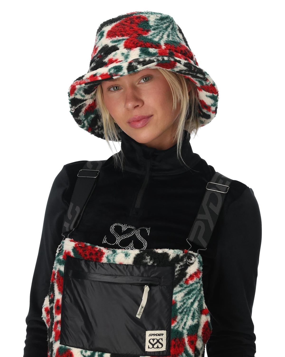 Person wearing a black outfit with suspenders and a floral-patterned hat on a white background