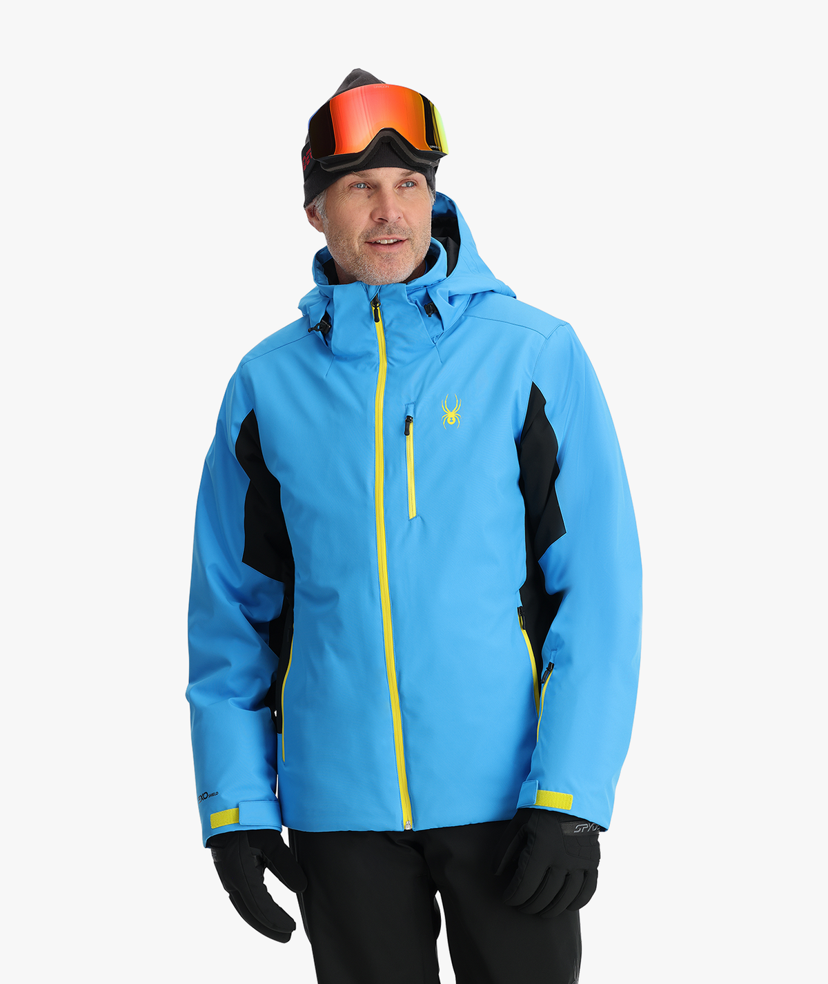 Person wearing a blue and black ski jacket with yellow accents on a white background