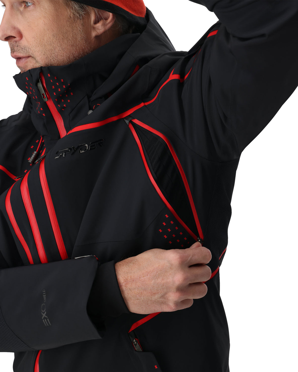 Person wearing a black jacket with red accents on a white background