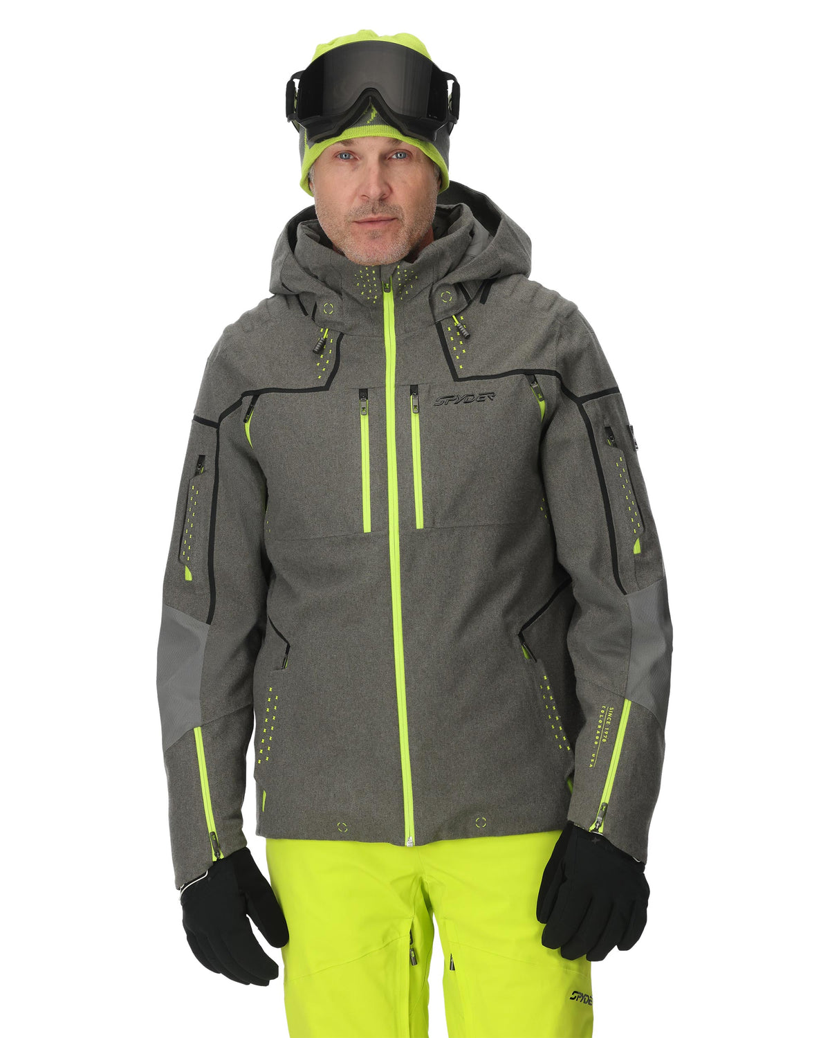 Person wearing a gray and green ski jacket with matching pants on a white background