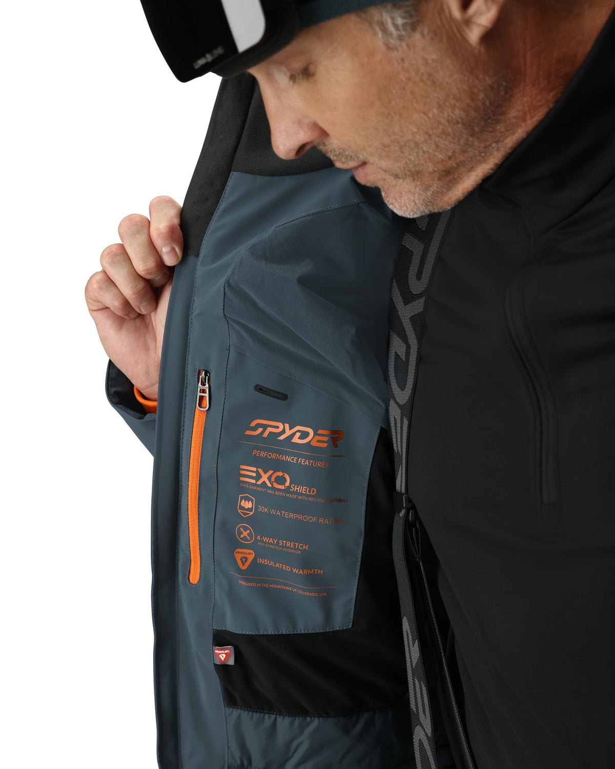 Person wearing a Spyder jacket with visible branding and product features.