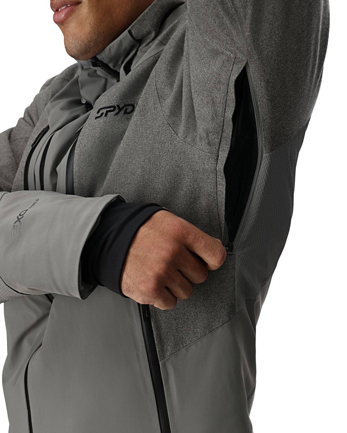 Person wearing a gray jacket with Spyder logo on a white background