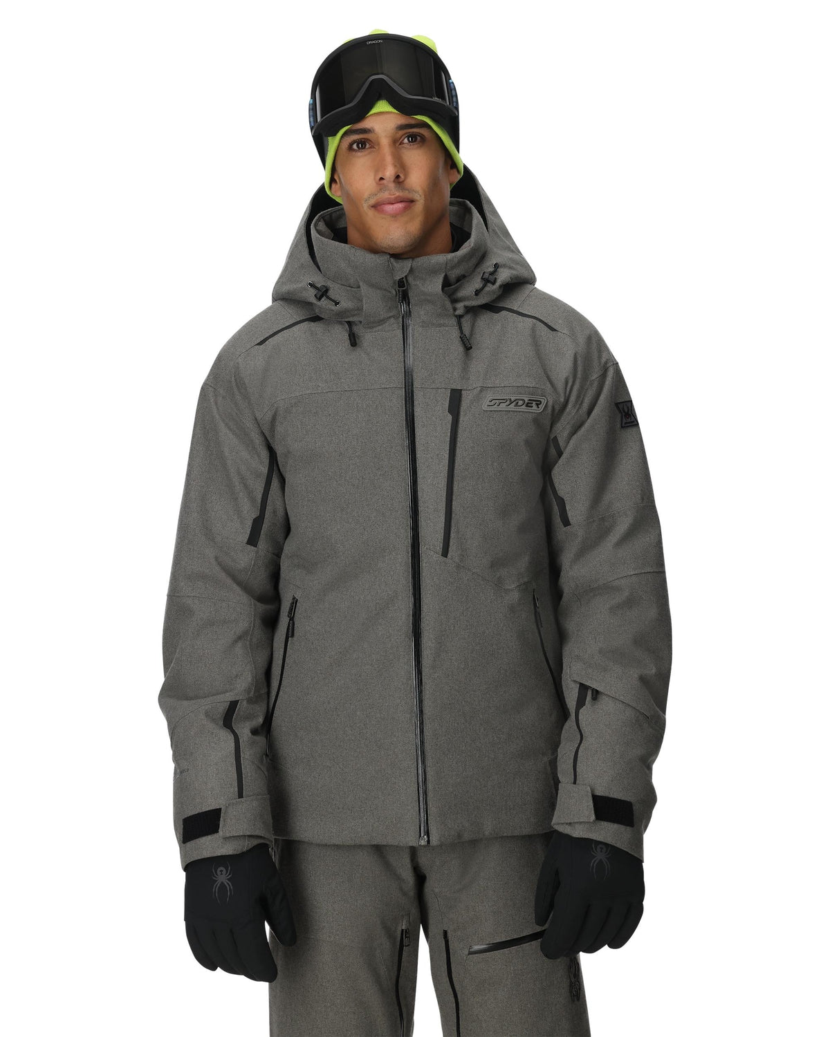 Person wearing a gray snow jacket and pants with goggles on a white background