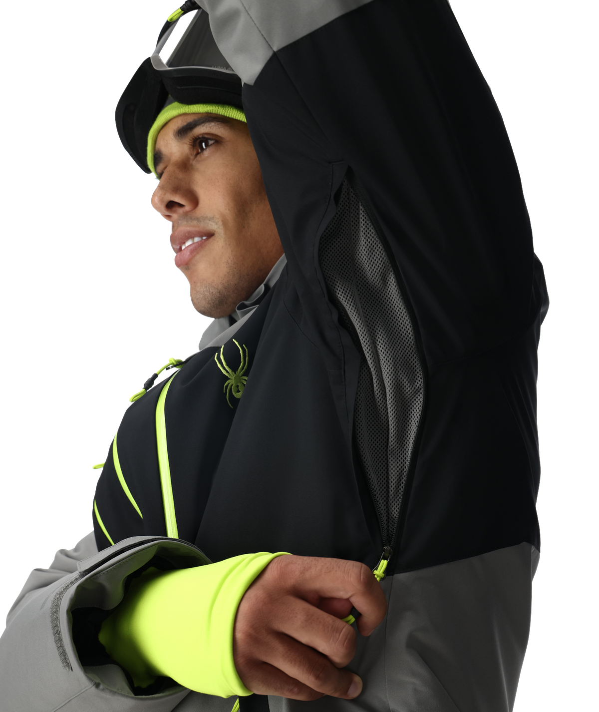 Person wearing a black and gray jacket with neon green accents on a white background