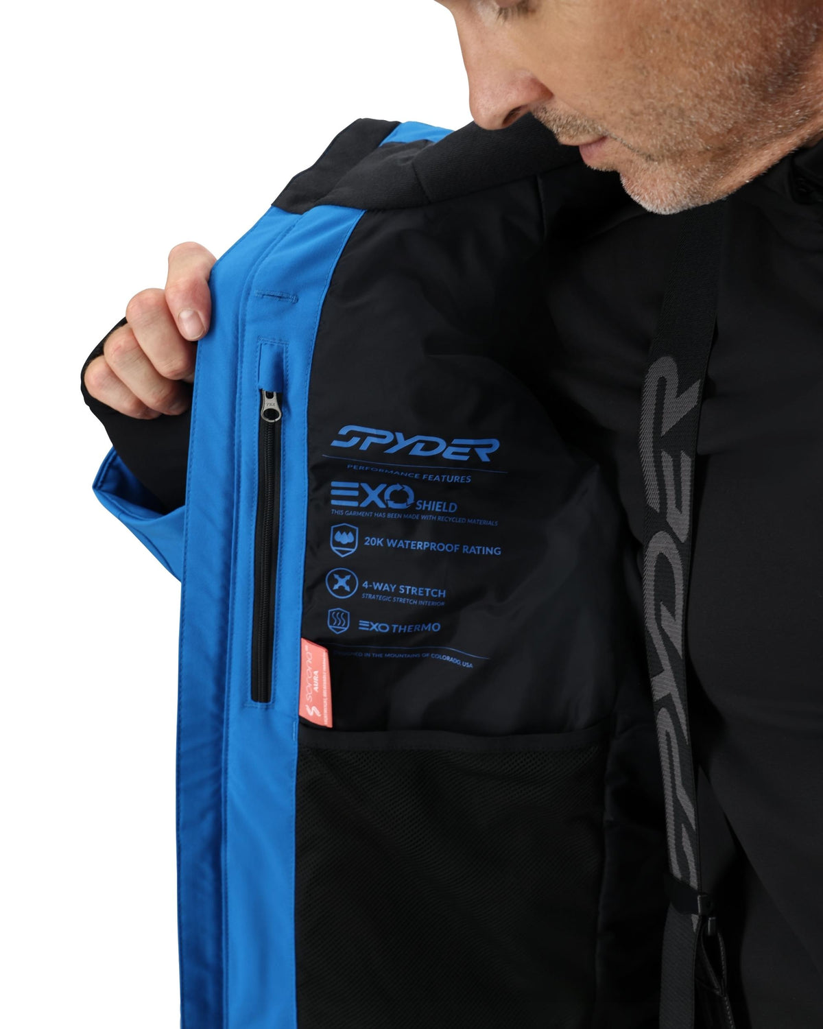 Person wearing a black and blue Spyder jacket with visible branding.