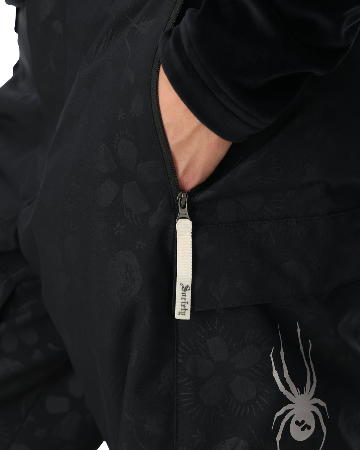 Close-up of a black jacket with a zipper and brand logo on a white background
