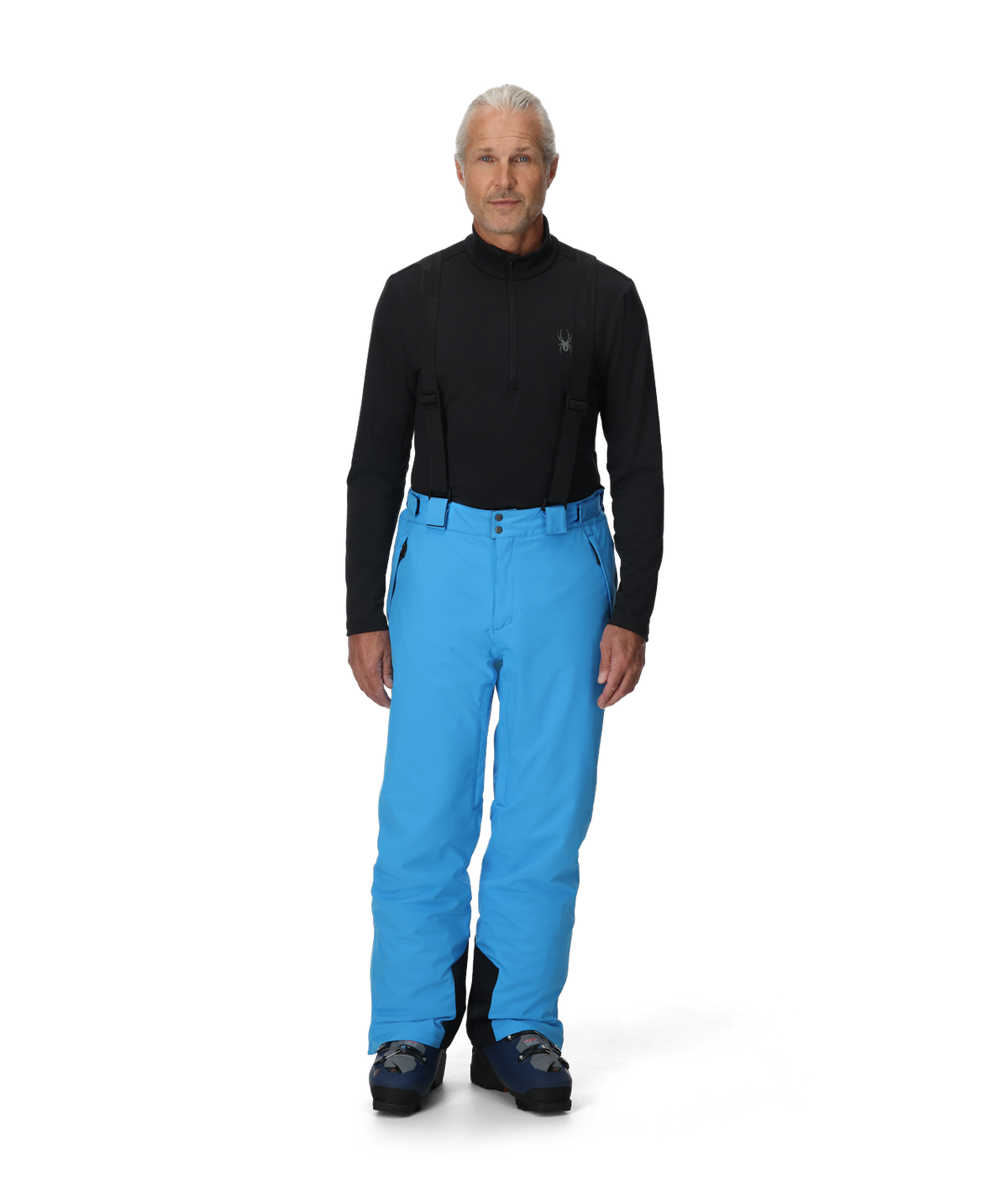 Person wearing a black top and blue pants on a white background