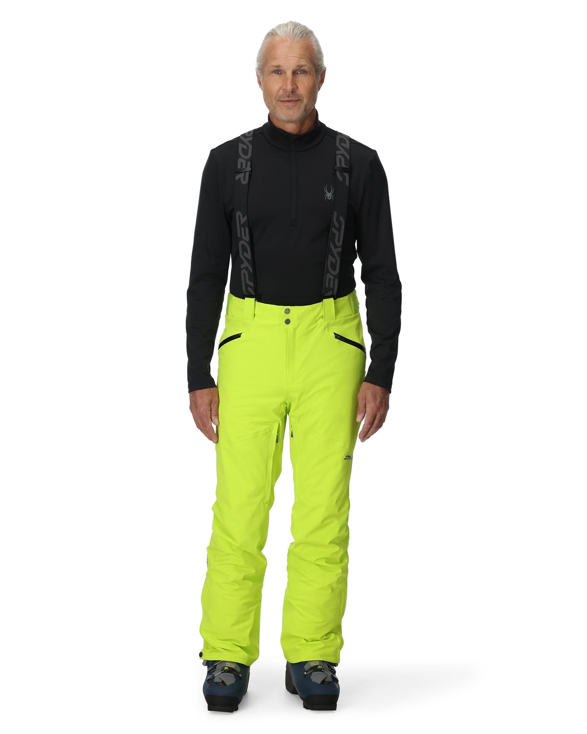 Person wearing a black top and bright yellow pants on a white background