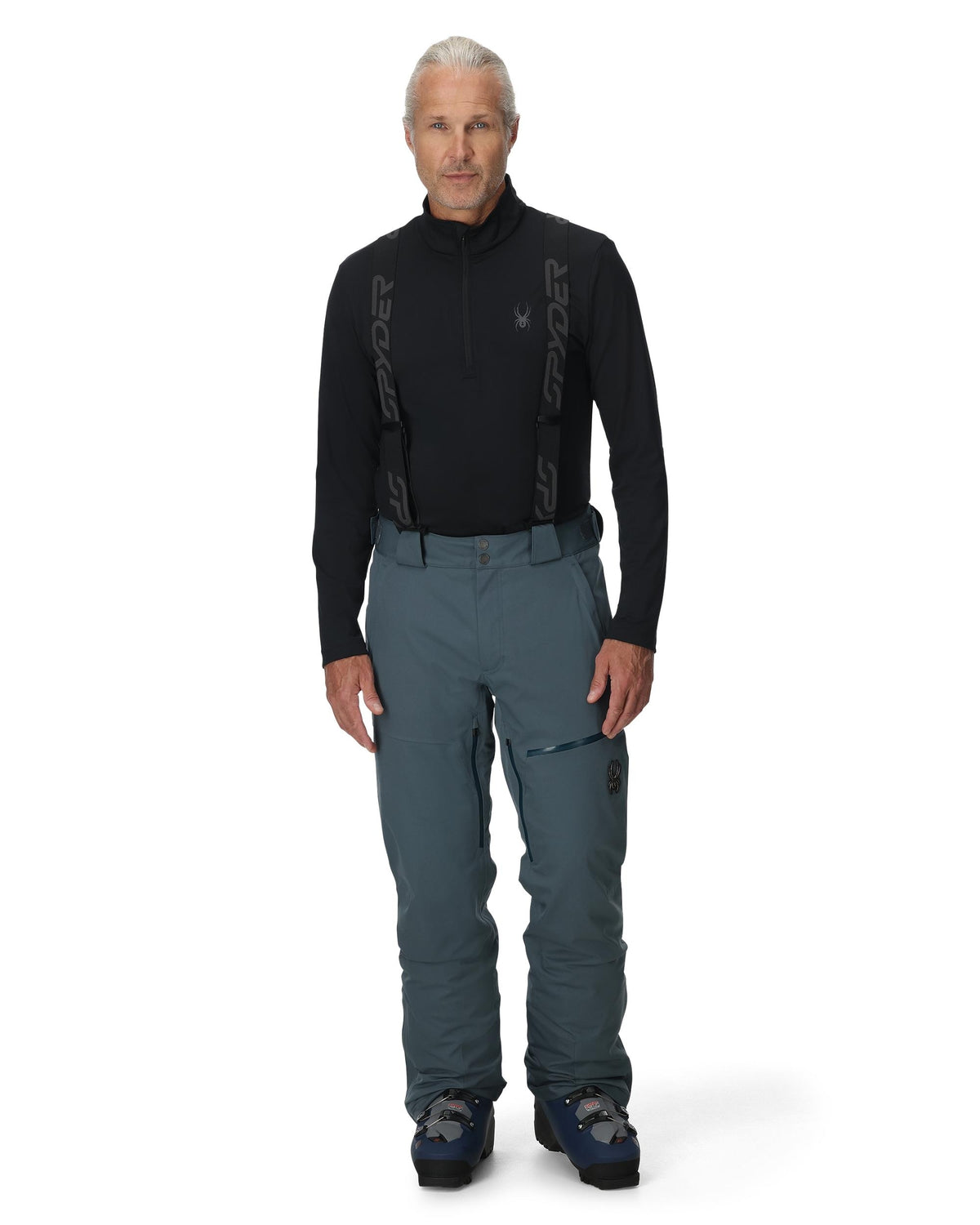 Man wearing a black long-sleeve top and gray pants on a white background