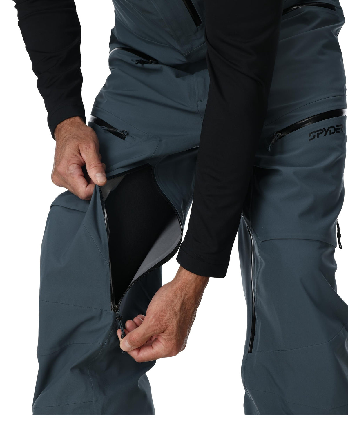 Close-up of dark gray pants with a brand logo on a white background