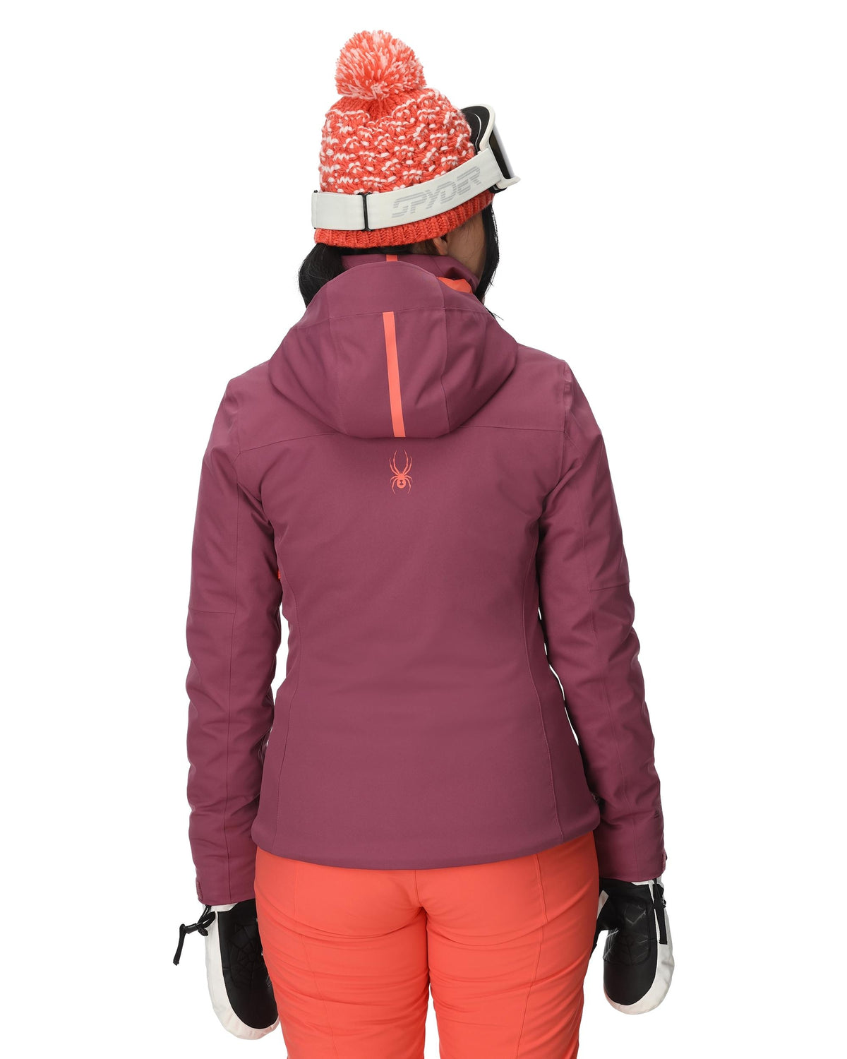 Person wearing a purple jacket and orange pants with a white background