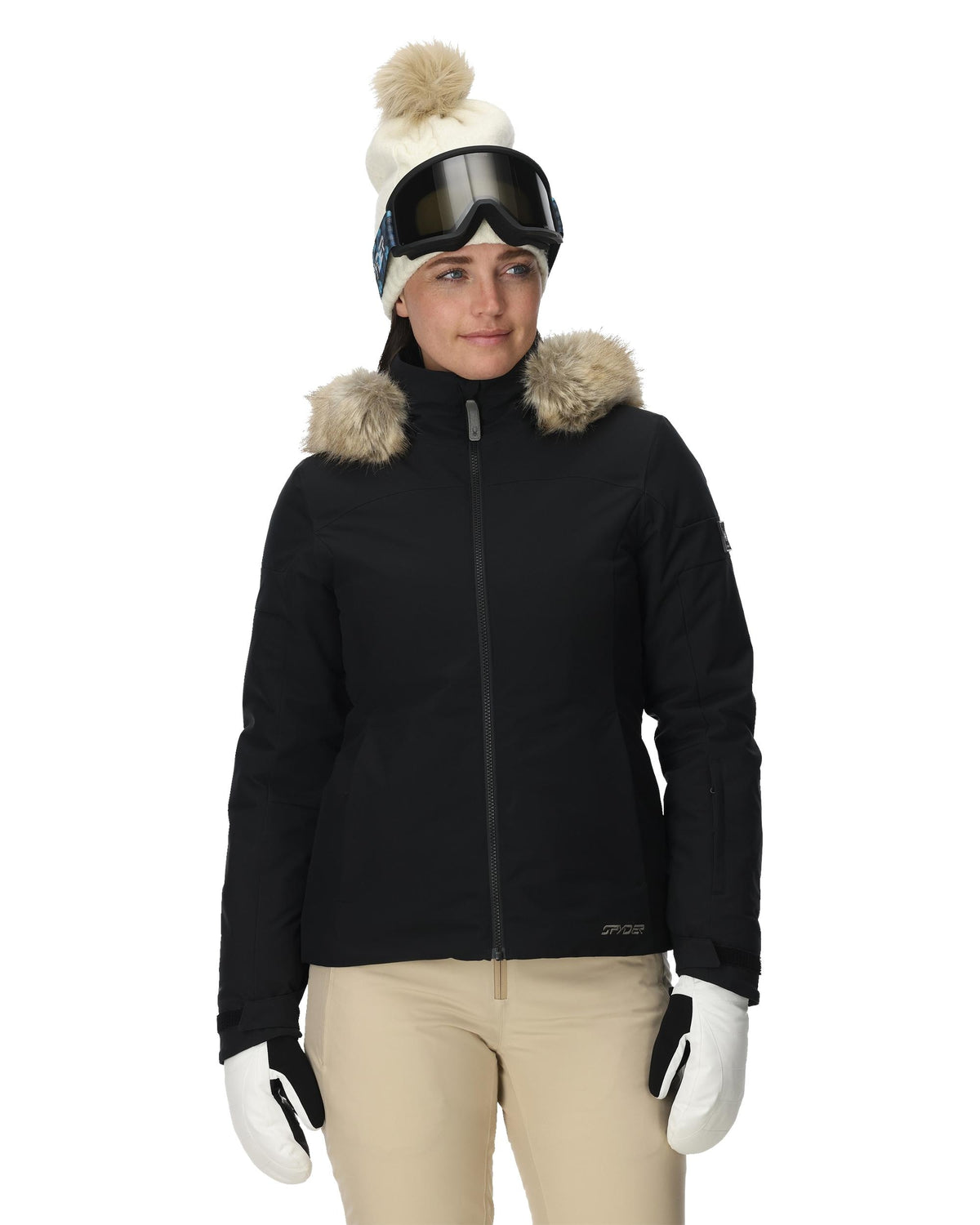 Person wearing a black jacket with fur-lined hood, white beanie, and goggles on a white background