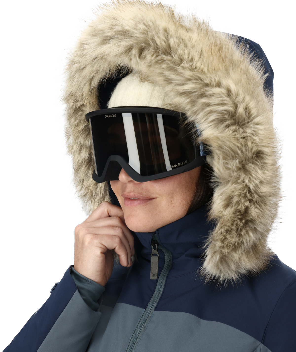 Person wearing a blue winter jacket with a fur-lined hood and black goggles on a white background