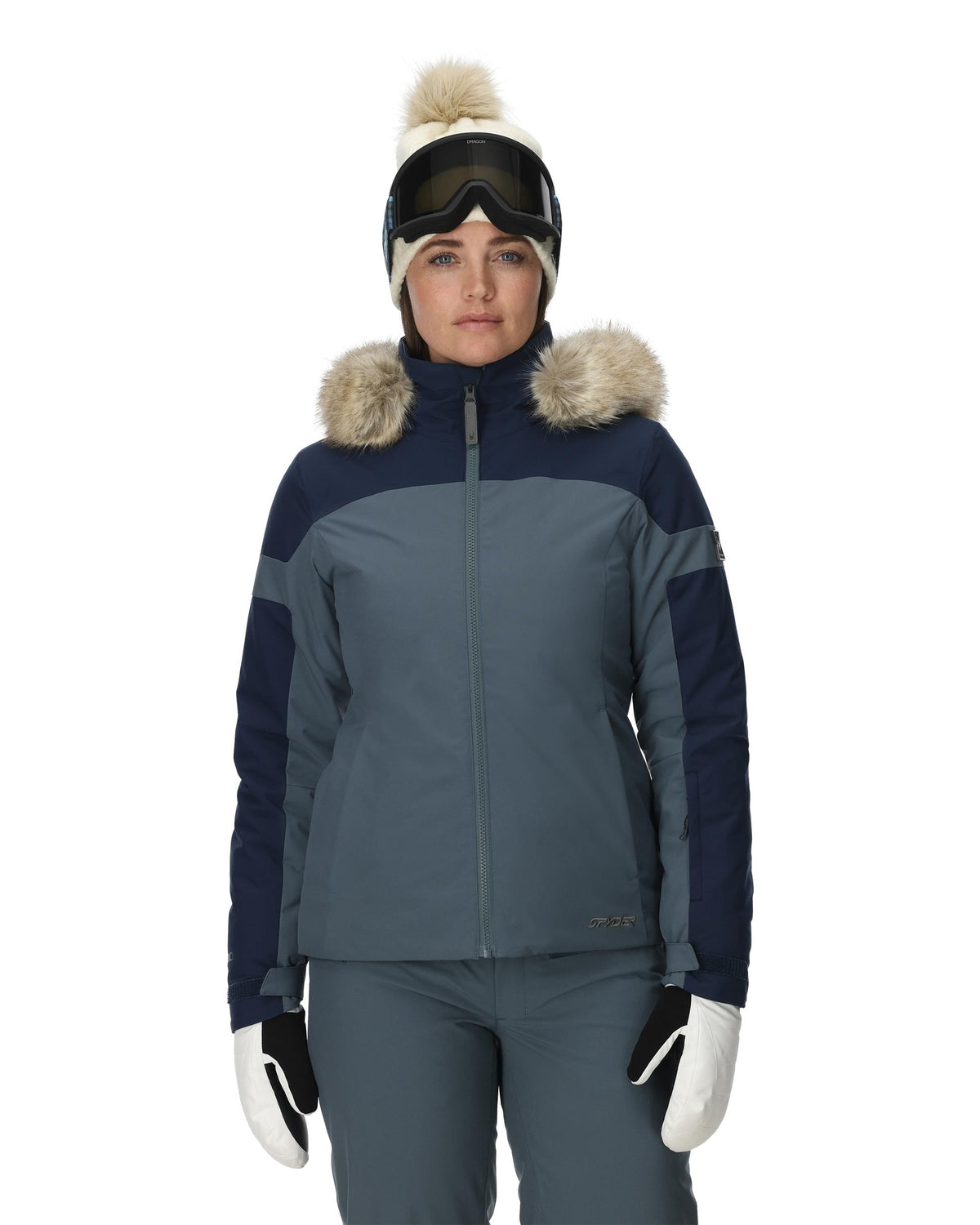 Person wearing a two-tone ski jacket with fur trim on a white background