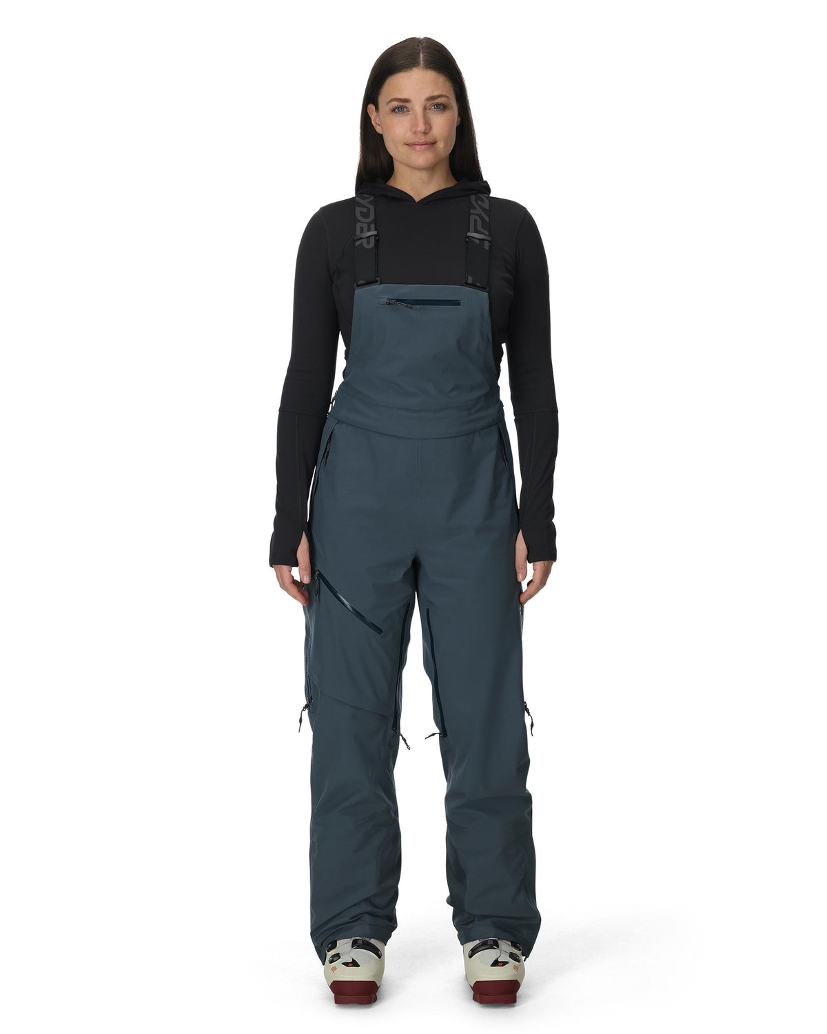 Person wearing a dark blue bib overalls on a white background