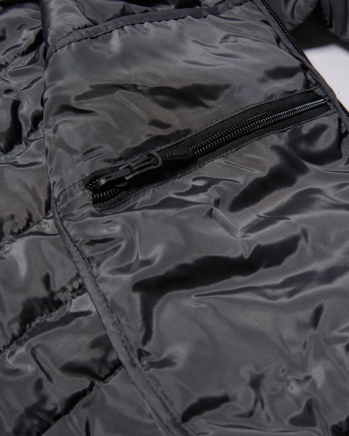 Close-up of a black jacket with a zipper on a white background