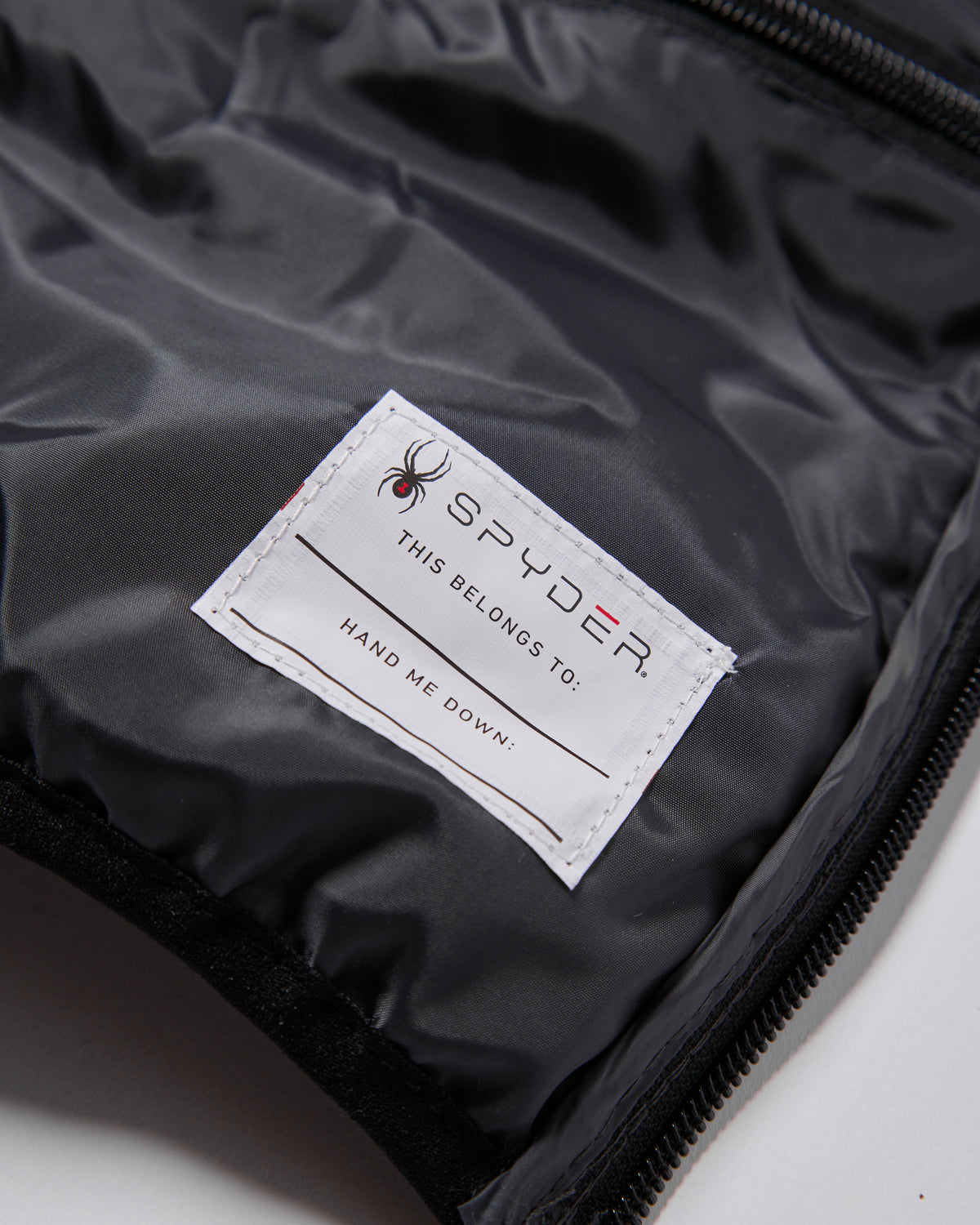 Spyder label on a black jacket with a spider logo