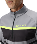 Close-up of a gray and black jacket with a yellow stripe featuring the Spyder logo.