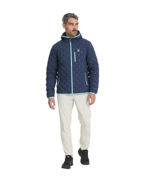 Man wearing a blue quilted jacket with a white background