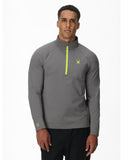 Man wearing a gray quarter-zip pullover with a logo on a white background