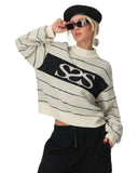 Person wearing a white sweater with black text and black pants on a white background