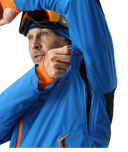 Person wearing a blue jacket with orange accents and goggles on a white background