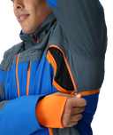 Person wearing a blue and gray jacket with orange accents, featuring the Spyder brand.