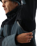 Person wearing a black and gray jacket with a hood, looking to the side.