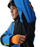 Person wearing a blue and black jacket with orange accents on a white background