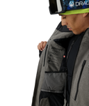 Person wearing a gray ski jacket with Spyder branding on a white background