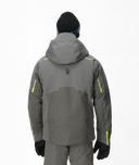 Person wearing a gray jacket with yellow accents on a white background