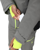 Person wearing a gray jacket with bright yellow cuffs and hem, holding a white card.