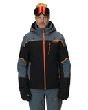 Person wearing a black and gray ski jacket with orange accents on a white background