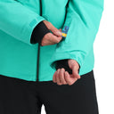 Person wearing a teal jacket with black cuffs, adjusting the zipper.