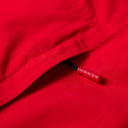 Close-up of a red fabric with a tag inside, on a red background