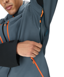 Person wearing a gray jacket with orange zippers on a white background