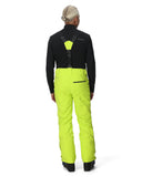 Person wearing a black jacket and bright yellow pants on a white background