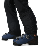 Blue ski boots with black pants on a white background