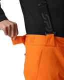 Close-up of orange pants with a black jacket featuring a logo on a white background