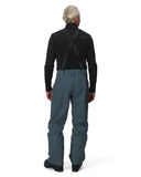 Person wearing a black jacket and gray pants on a white background