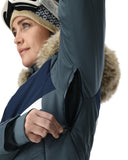 Person wearing a blue winter coat with fur-lined hood on a white background