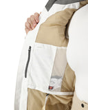 Close-up of a person wearing a beige and white jacket with a mesh pocket.