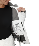 Person wearing a white and gray jacket with Spyder branding on a white background